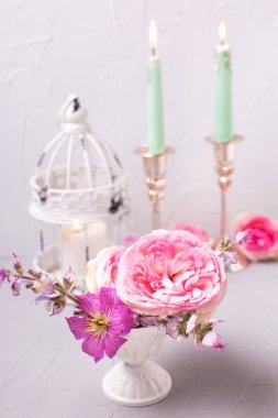 pembe çiçekler ve gri dokulu arka plan üzerinde yanan mumlar