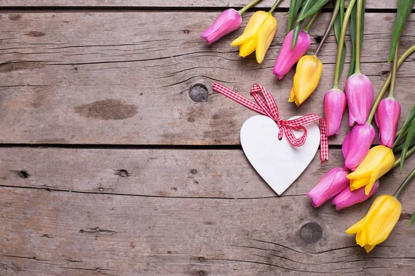 Corazón Blanco Decorativo Tulipanes Primavera Rosados Amarillos Sobre Fondo Madera —  Fotos de Stock