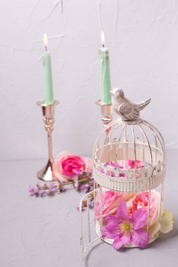 Yaz çiçek dekoratif fener ve gri dokulu arka plan üzerinde yanan mumlar. Seçici odak.