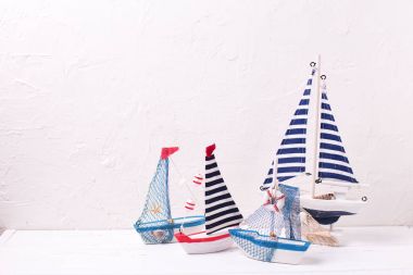 Dekoratif ahşap oyuncaklar tekneler dokulu beyaz zemin üzerine.