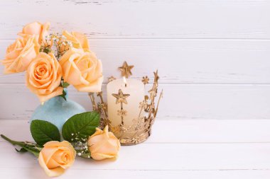 Şeftali güller çiçek mavi vazo ve Beyaz ahşap zemin üzerinde yanan mum