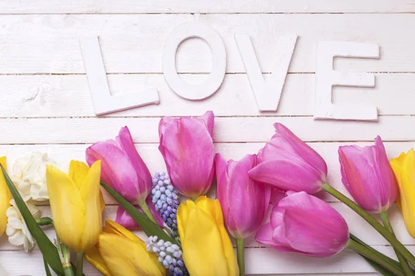Ανοιξιάτικα λουλούδια και λέξη αγάπη — Φωτογραφία Αρχείου
