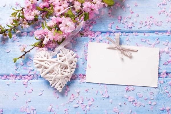 Flores sakura rosa, coração decorativo e etiqueta vazia — Fotografia de Stock