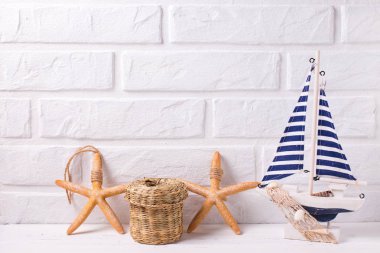 Dekoratif ahşap oyuncak tekne ve deniz yıldızı Beyaz ahşap zemin üzerinde. Metin için yer. Yaz, tatil kavramı.