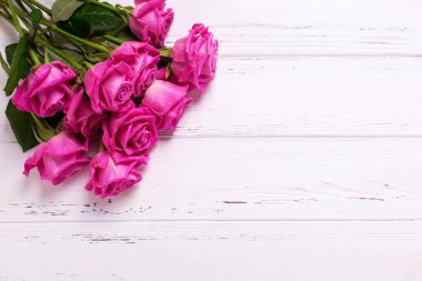 Pembe Gül çiçek Beyaz ahşap zemin üzerinde demet. Çiçekli natürmort. Metin için yer.