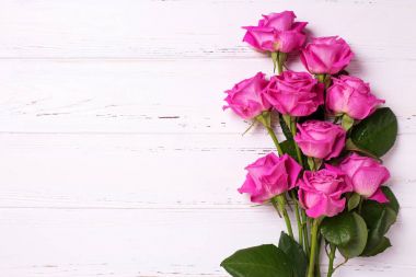 Pembe Gül çiçek Beyaz ahşap zemin üzerinde demet. Çiçekli natürmort. Metin için yer.