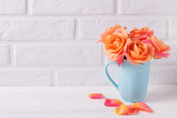 白い壁に木製白地青カップ新鮮なオレンジのバラ テキストを配置します 花のある静物 — ストック写真