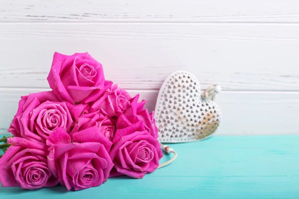 明るいピンクのバラの花と白い壁に青緑色の木製の背景に心の束 選択と集中 テキストのための場所 — ストック写真