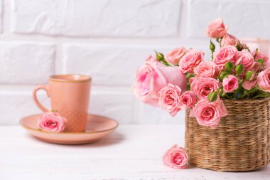 Pembe Gül çiçek ve kahve beyaz duvara karşı. Çiçekli natürmort. Seçici odak. Metin için yer.