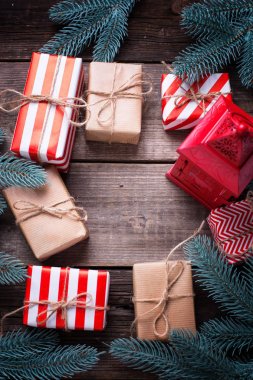 Bright hediye kutuları sarılmış, dekoratif fener ve dalları üzerinde vintage ahşap arka plan ağaç kürk ürünleri. Seçici odak. Metin için yer. Dikey görüntü.