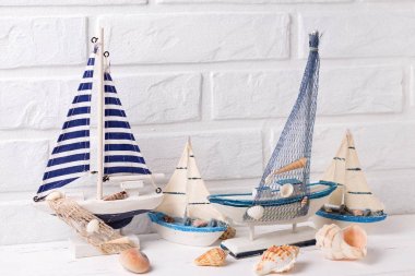 Okyanus yaşam süslemeleri. Dekoratif tekneler ve beyaz tuğla duvar tarafından yakınındaki kabukları. Seçici odak. 