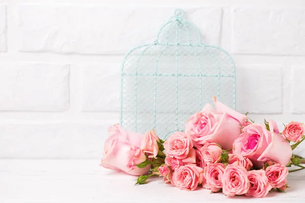 粉红色玫瑰花和装饰蓝笼反对白砖墙 花静物 选择性对焦 文本位置 — 图库照片