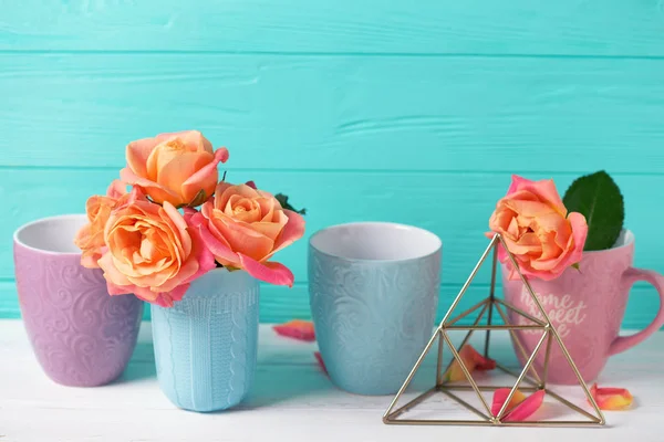 Fesh オレンジバラとターコイズ ブルーの壁にカラフルなカップ テキストを配置します 花の静物画 選択と集中 — ストック写真
