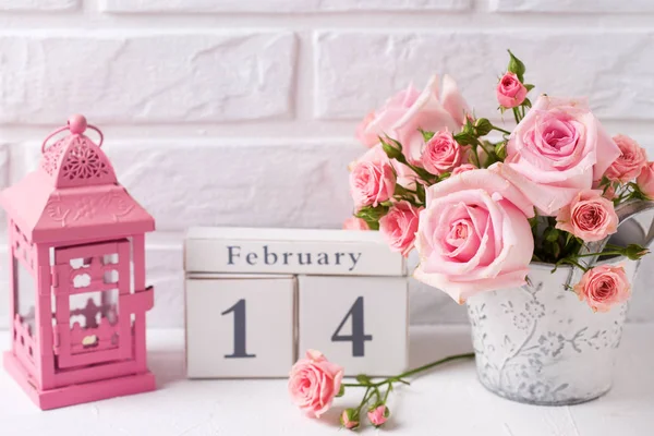 圣情人节背景 一束嫩粉红色的玫瑰花 日历和装饰粉红色的灯笼 反对白砖墙 花静物 选择性聚焦 — 图库照片
