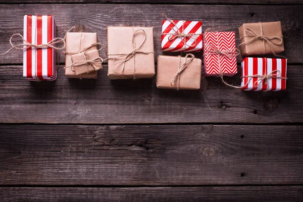 Border from gift boxes with presents   on vintage wooden background. Selective focus. Top view. Place for text.