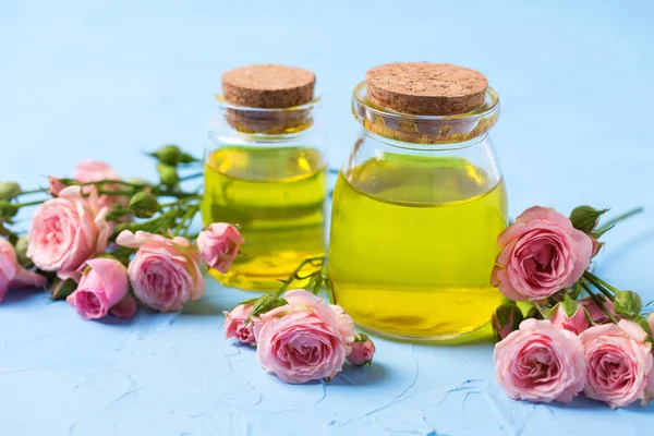 Natürliche Bio Kosmetik Flaschen Mit Rosenöl Und Rosenblüten Auf Blau — Stockfoto