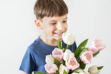 Bir sürü lale tutan şirin bir çocuk. Anneler Günü kutsanmıştır..