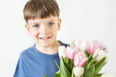 Bir sürü lale tutan şirin bir çocuk. Anneler Günü kutsanmıştır..