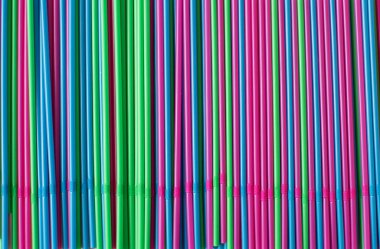 Pembe arka planda renkli pipetler. Plastik, yeniden kullanılabilir plastik, çevre dostu.