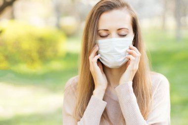 Koronavirüs salgını sırasında dışarıda maske takan bir kadın..