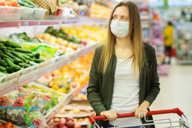 Tıp maskeli kadın süpermarkette alışveriş yapıyor..