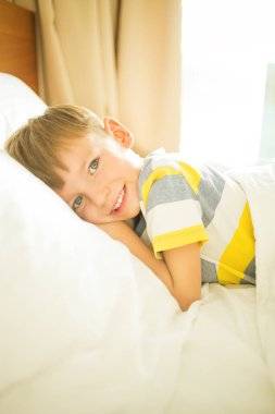 Küçük çocuk ebeveynin yatağında eğleniyor..