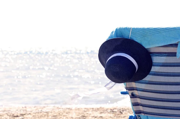 Tatil ve rahatlama konsepti. Deniz kenarında bir tatil köyü, sandalye, havlu ve eski moda bir kulübe. Açık ve güneşli bir yaz günü. Denizde huzurlu, tembel bir tatil fikri.