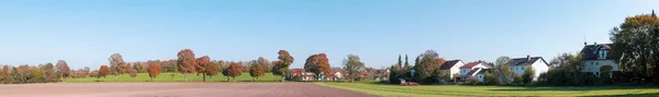 Rural landscape, panoramic view of a small village, with a tractor workingin a field, few houses and many trees with autumn yellow foliage. Bavarian countryside, Germany — Stock Photo, Image