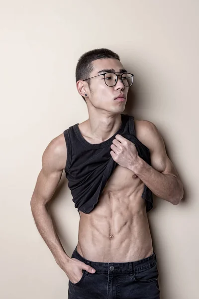 Joven sexy hombre en gafas posando y mostrar su cuerpo — Foto de Stock