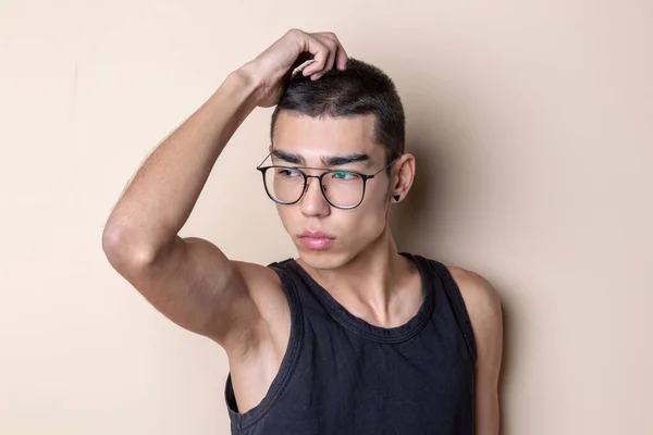 Ung sexig man i glasögon poserar och tittar på kameran — Stockfoto