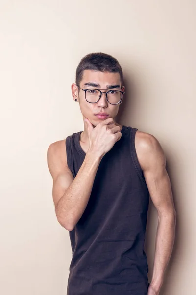 Joven sexy hombre en gafas posando y mirando a la cámara — Foto de Stock