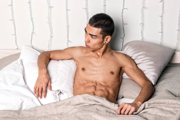 Young handsome man rest in bed. Sexy naked guy is resting — Stock Photo, Image