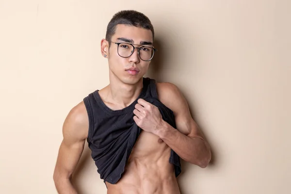 Joven sexy hombre en gafas posando y mostrar su cuerpo — Foto de Stock