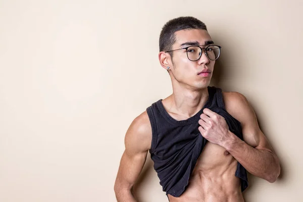 Joven sexy hombre en gafas posando y mostrar su cuerpo — Foto de Stock