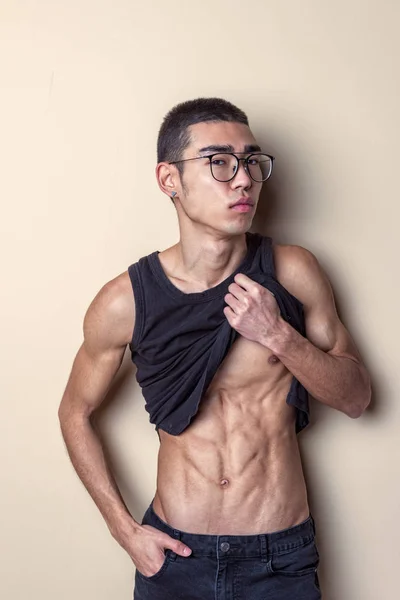 Joven sexy hombre en gafas posando y mostrar su cuerpo — Foto de Stock