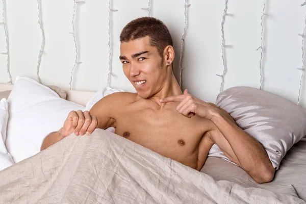 Young handsome man rest in bed. Sexy naked guy is resting — Stock Photo, Image