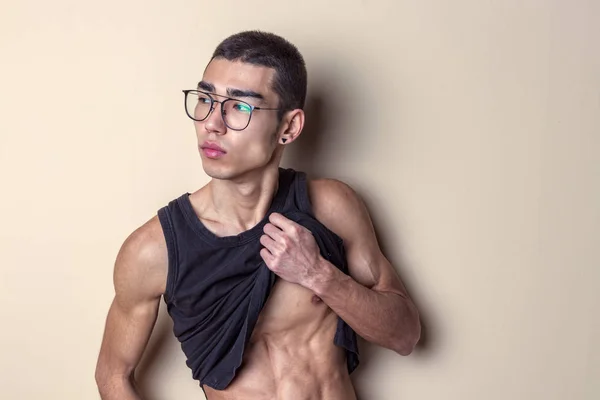 Joven sexy hombre en gafas posando y mostrar su cuerpo — Foto de Stock