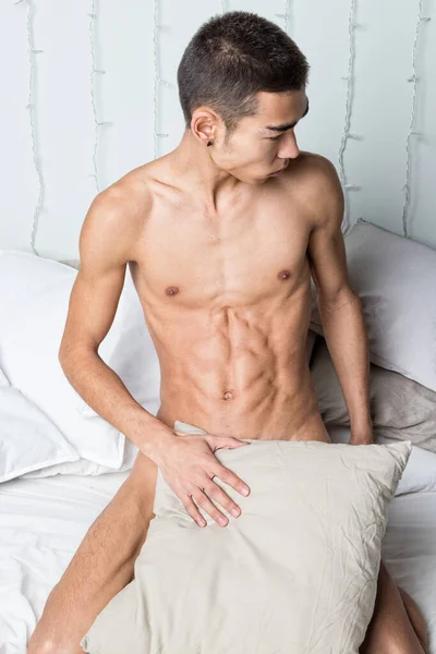 Joven hombre guapo descansar en la cama. Sexy chico desnudo está descansando — Foto de Stock