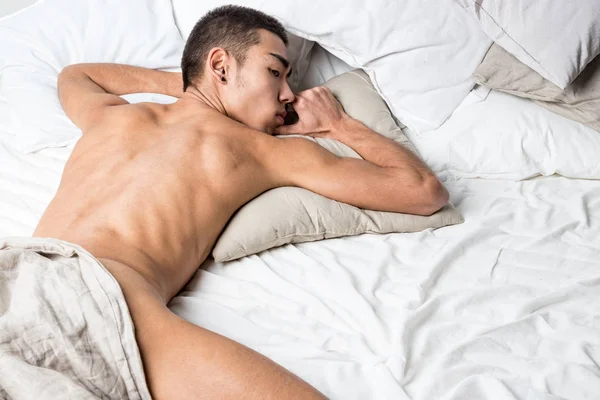 Junger schöner Mann ruht sich im Bett aus. sexy nackter Kerl ruht sich aus — Stockfoto