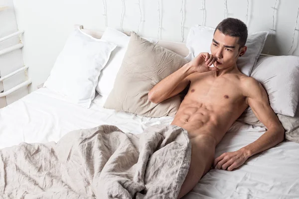 Young handsome man rest in bed. Sexy naked guy is resting — Stock Photo, Image