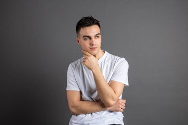 Stüdyoda poz veren ciddi bir genç.