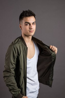 Stüdyoda poz veren ciddi bir genç.