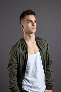 Stüdyoda poz veren ciddi bir genç.