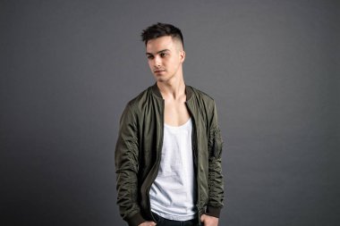 Stüdyoda poz veren ciddi bir genç.