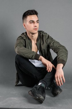 Stüdyoda poz veren ciddi bir genç.