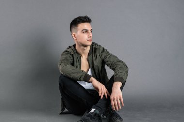 Stüdyoda poz veren ciddi bir genç.