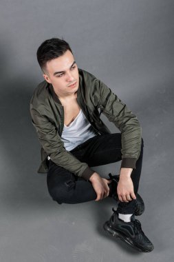 Stüdyoda poz veren ciddi bir genç.