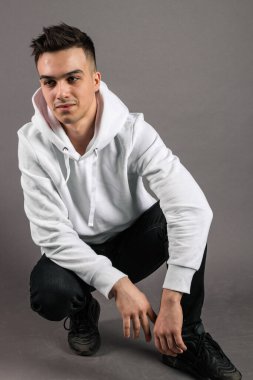 Stüdyoda poz veren ciddi bir genç.