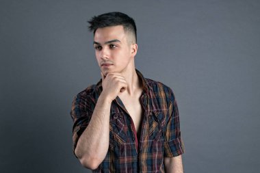 Stüdyoda poz veren ciddi bir genç.