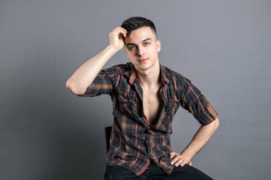 Stüdyoda poz veren ciddi bir genç.